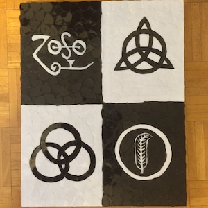 May include: Black and white mosaic artwork featuring the Led Zeppelin band logo. The logo is made up of four symbols: a stylized "Zoso", a circle with a feather, a circle with three interlocking rings, and a triangle with three interlocking rings.