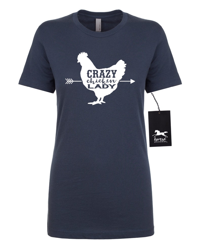 May include: Navy blue t-shirt with a white graphic of a chicken and the text "Crazy Chicken Lady". The shirt has short sleeves and a crew neck. A black tag with a horse logo is attached.