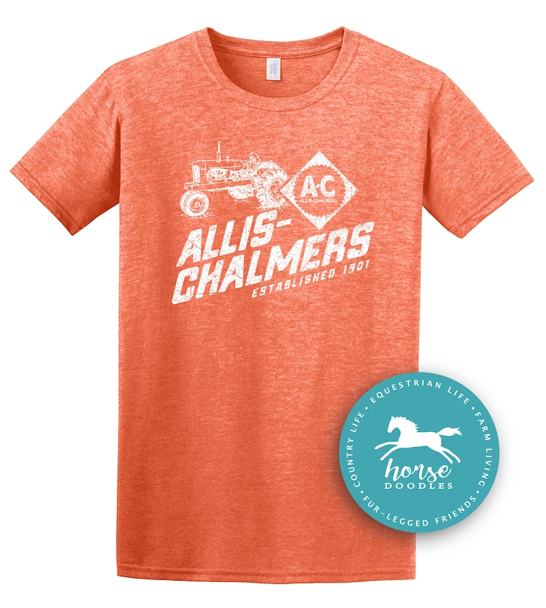 May include: Orange short-sleeved t-shirt with a distressed white graphic featuring a tractor and the text "ALLIS-CHALMERS ESTABLISHED 1901". A circular logo with a horse is on the bottom right.