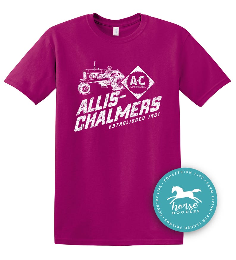 May include: A magenta t-shirt featuring a white graphic of a vintage tractor and the text "ALLIS-CHALMERS ESTABLISHED 1901". A circular logo with a horse graphic is on the bottom right.