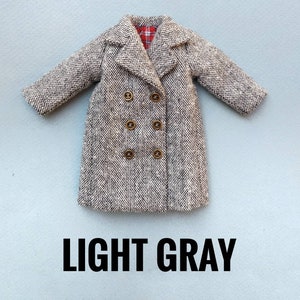 May include: A light gray double-breasted coat with a plaid lining. The coat has five gold buttons.