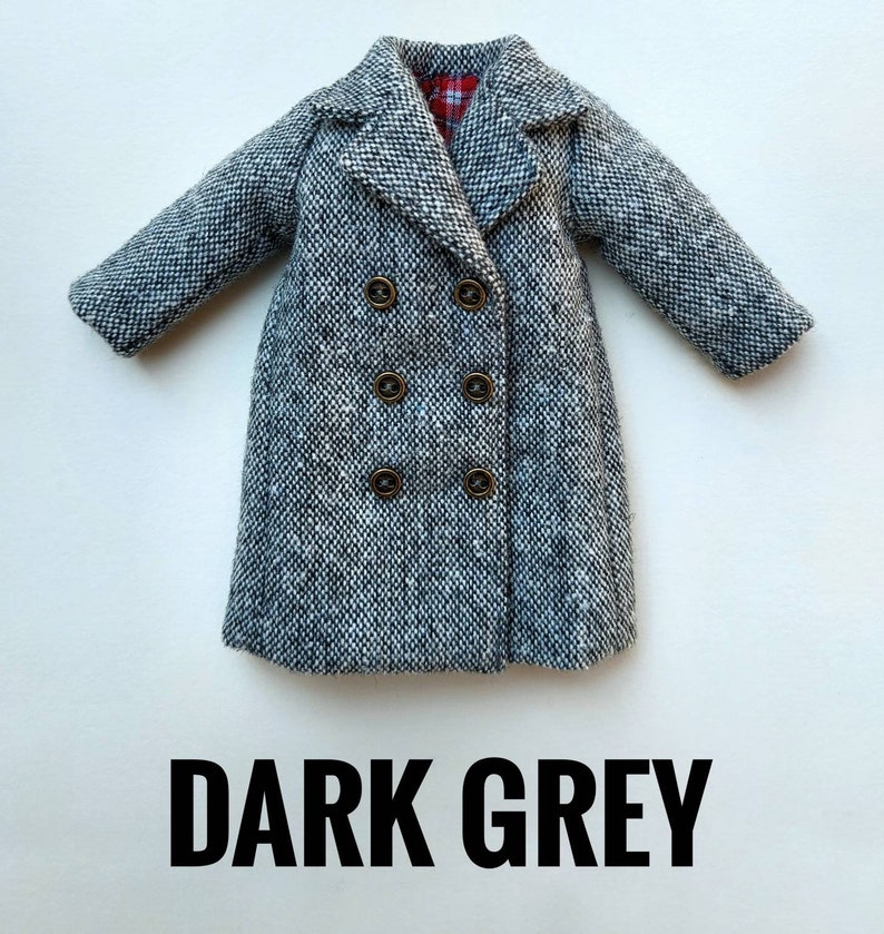 May include: A dark gray tweed coat with a double breasted closure and four gold buttons. The coat has a collar and long sleeves.