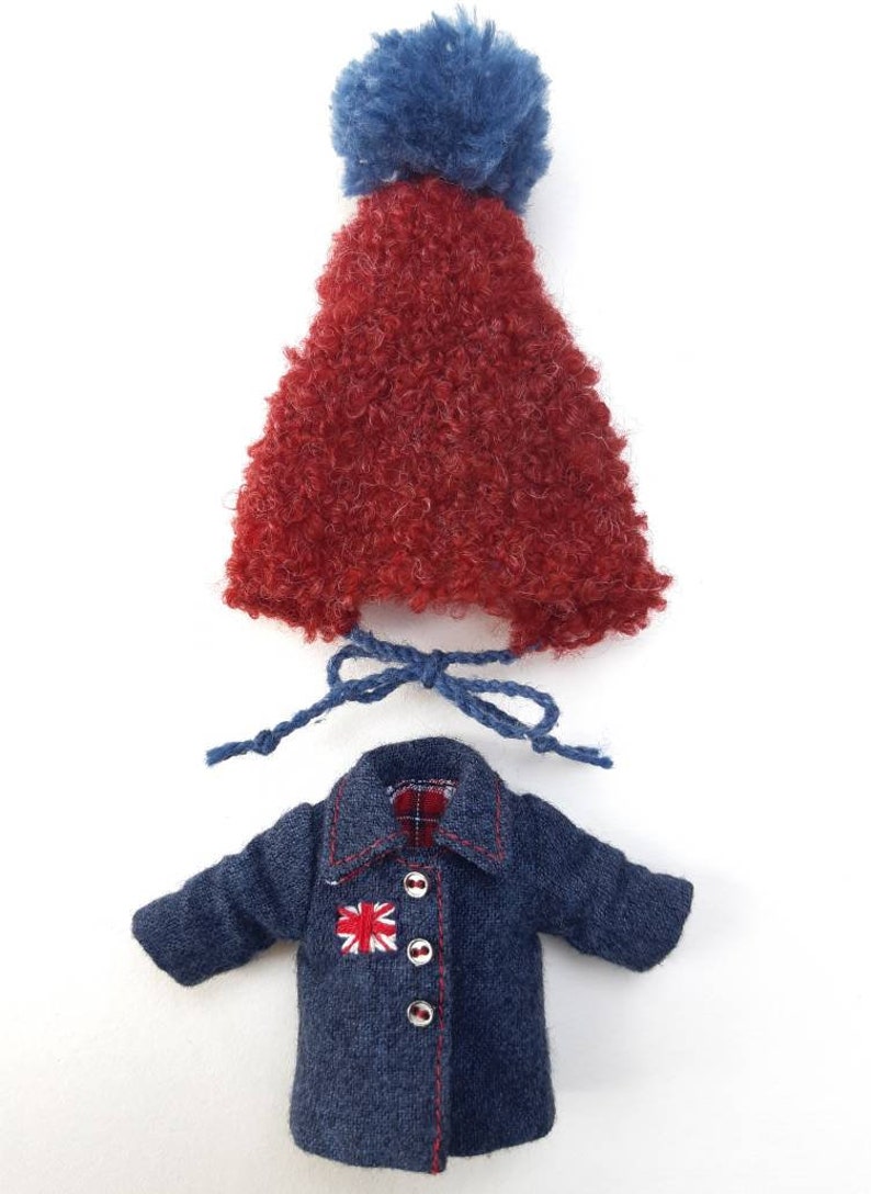 May include: A red fuzzy hat with a blue pom pom and a blue denim jacket with a red and white Union Jack patch and red stitching.