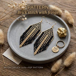 May include: A pair of long, geometric earrings crafted with black and gold beads in a brick stitch pattern with fringe. The text reads PATTERN Brick stitch with fringe, OksiAnna, and PDF INSTANT DOWNLOAD on a small round tag.