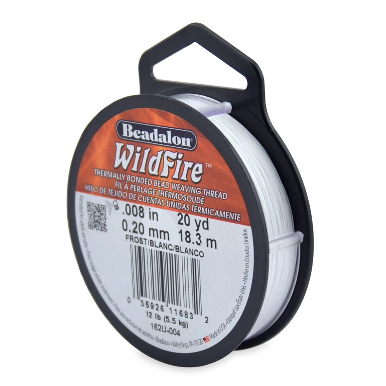 May include: A spool of white Beadalon WildFire thermally bonded bead weaving thread. The spool is labeled with the brand name, product name, and details about the thread, including the size, length, and color. The text on the label reads: "Beadalon WildFire, Thermally Bonded Bead Weaving Thread, Fil &agrave; Perlage Thermosoud&eacute;, Hilo de Tejido de Cuentas Unidas Termicamente, .008 in, 20 yd, 0.20 mm, 18.3 m, Frost/Blanc/Blanco".