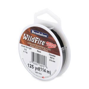 May include: A spool of black Beadalon WildFire Ultra bead weaving thread. The label specifies a break strength of 9 lb, a diameter of .004 in, and a length of 125 yd. The white plastic spool features a hanging tab and a barcode for identification.