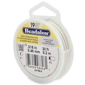 May include: A spool of 19 strand silver colored beadalon bead stringing wire. The spool is 30 feet long and 0.018 inches in diameter. The label reads "Beadalon Bead Stringing Wire" and "Silver Color".