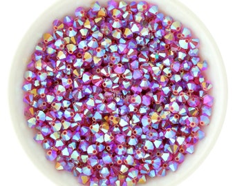 May include: A bowl filled with iridescent pink and gold crystal beads. The beads are faceted and have a star-shaped design.