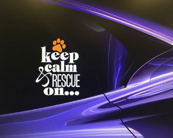 Op de afbeelding: Een witte vinyl sticker met een oranje pootprint en de tekst "keep calm & rescue on..." op een paarse auto.