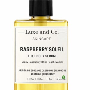 Op de afbeelding: Een heldere, rechthoekige Luxe and Co. huidverzorgingsfles met een zwarte pompdosator. De fles bevat een gele body serum met het label "Raspberry Soleil" met ingredi&euml;nten. Beschikbare maten zijn 59ml, 100ml, 118ml en 177ml of 200ml.