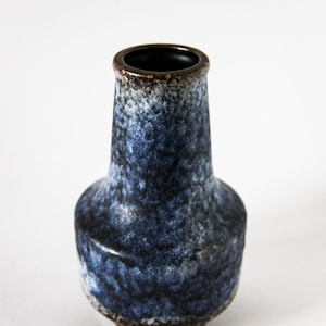 May include: A small blue and brown ceramic vase with a speckled glaze.
