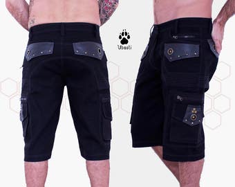 Könnte beinhalten: Schwarze Cargo-Shorts mit Lederakzenten und mehreren Taschen. Die Shorts haben einen Reißverschlussdetail an der Seite und ein Ubasti-Logo am rechten Bein.
