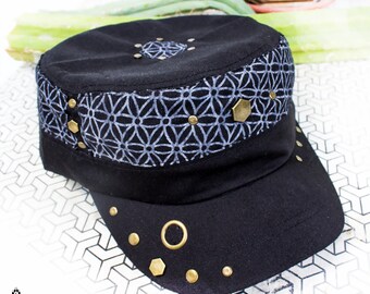 Könnte beinhalten: Eine schwarze Militärkappe aus Canvas mit einem geometrischen Musterband und goldenen Akzenten.