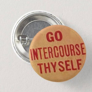 Könnte beinhalten: Ein runder Knopf mit braunem Hintergrund und rotem Text, der "GO INTERCOURSE THYSELF" lautet.