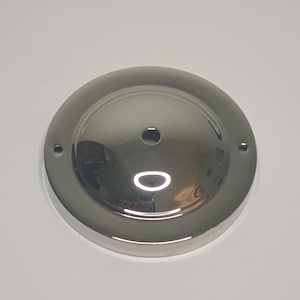 May include: A chrome ceiling plate with two holes and a center hole for a light fixture.