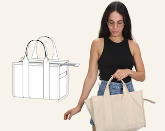 May include: A woman is holding a beige tote bag with two handles. The bag has a zipper on the side. The woman is wearing a black tank top and denim shorts. A line drawing of a similar tote bag is in the background.