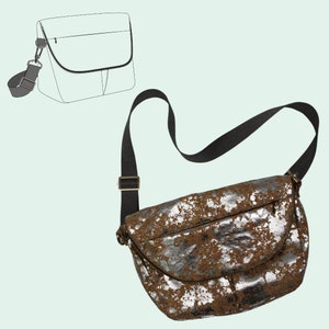 May include: A brown leather crossbody bag with silver paint splatter. The bag has a flap closure and a long adjustable strap.