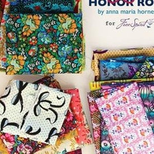 May include: A collection of fabric fat quarters in a variety of colourful patterns, including floral, geometric, and abstract designs. The fabric is arranged in stacks and labelled "Honor Roll" by Anna Maria Horner for Free Spirit.