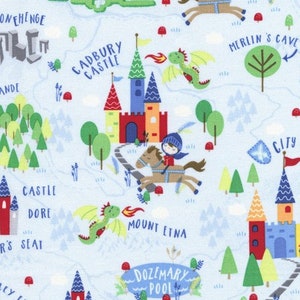 Può includere: Un tessuto blu e bianco con un design di mappa fantasioso che presenta castelli, draghi e un cavaliere a cavallo. La mappa include nomi come Cadbury Castle, Mount Etna, Dozemary Pool e Merlin's Cave.