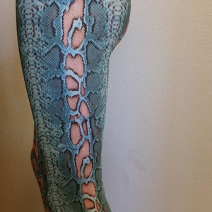 May include: Teal and pink snakeskin print leggings. The leggings are cropped and have a high waist.