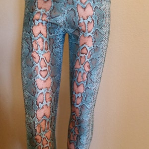 May include: Blue and pink snake print leggings with a high waist.