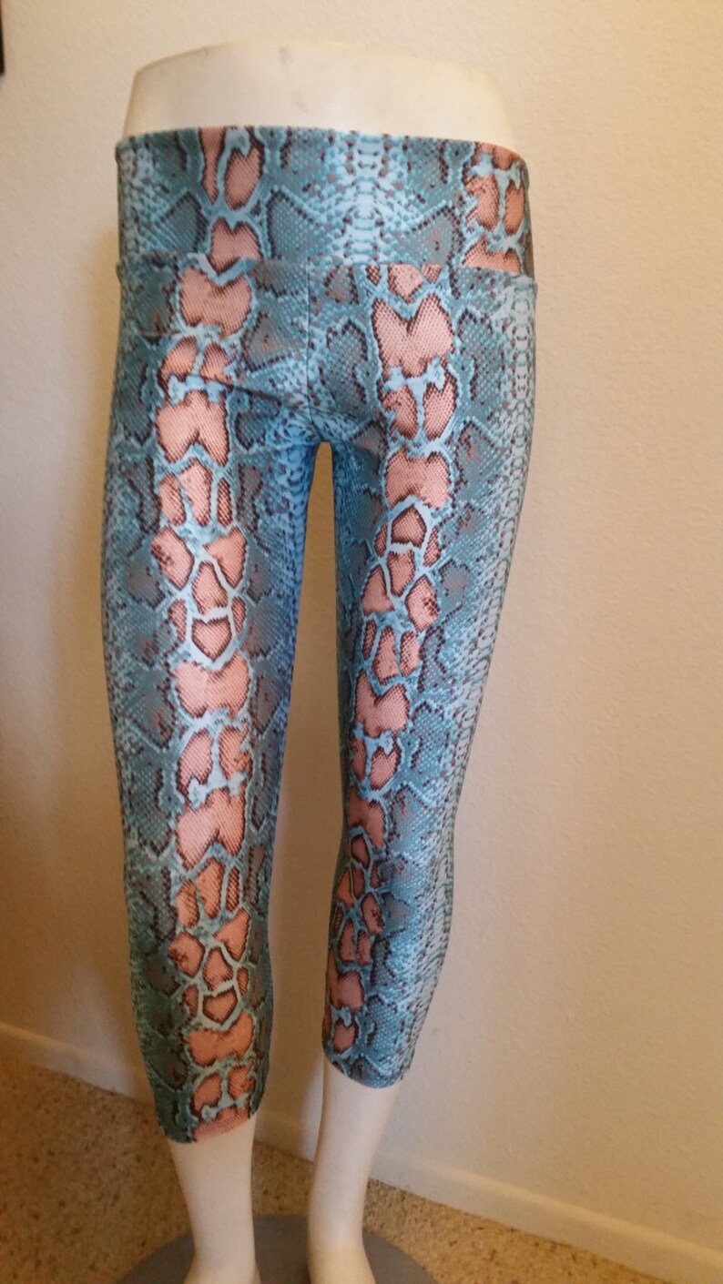 May include: Blue and pink snake print leggings with a high waist.