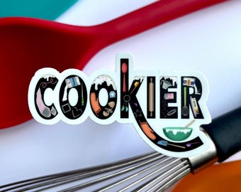May include: A white sticker with the word "cookier" written in black. The letters are filled with various kitchen tools and ingredients, such as a whisk, rolling pin, measuring cups, and a spatula.