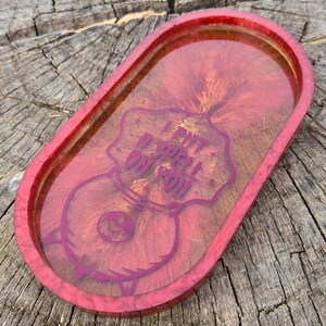 Op de afbeelding: Rode ovale harsbak met een roze en gouden swirl-ontwerp. De bak heeft een roze afbeelding van een ketel met de tekst "I put a spell on you".