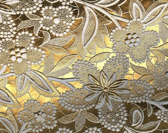 May include: A decorative paper sheet featuring a metallic gold background with an embossed white floral pattern. The design consists of intricate flowers and leaves with textured details. The text PaperSource is printed in the bottom right corner.