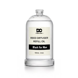 May include: A clear glass bottle containing reed diffuser refill oil. The label features the text DC NEW YORK, REED DIFFUSER REFILL OIL, Black For Men, and 100mL 3.4oz. The bottle has a cylindrical shape with a screw-top cap and clear liquid inside.