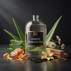 May include: A clear glass bottle with a black and gold label that reads "Amber Romancing" is surrounded by aloe vera, amber stones, vanilla beans, and flowers. The website www.DaniellasCandles.com is printed on the label. The background is dark.