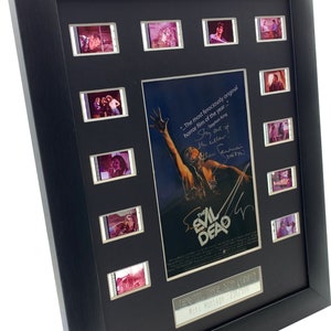May include: A black framed movie cell montage of the 1981 horror film "The Evil Dead." The montage includes 9 film cells and a poster with a quote from Stephen King. The poster features a man with his arms raised in the air. The text on the poster reads "The most ferociously original horror film of the year..." and is signed by Bruce Campbell. The plaque below the montage reads "Evil Dead (1981) Mini Montage: 236/500."
