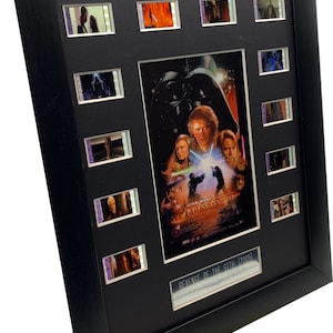 Könnte beinhalten: Ein gerahmtes Filmplakat und eine Sammlung von Filmzellen für Star Wars Episode III: Die Rache der Sith (2005). Das Plakat zeigt Darth Vader, Anakin Skywalker, Obi-Wan Kenobi und Yoda. Die Filmzellen zeigen Szenen aus dem Film.