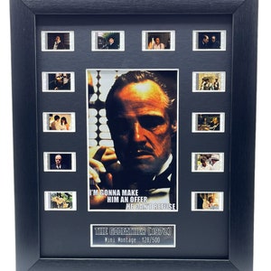 May include: A black framed movie montage of The Godfather (1972) with a close-up image of Marlon Brando as Don Vito Corleone. The montage includes 10 film strips and the text "I'm gonna make him an offer he can't refuse." The montage is numbered 128/500.