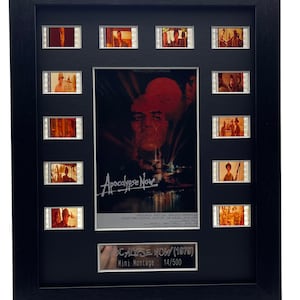 Może przedstawiać: Czarna rama z montażem filmowym z paskami filmu z filmu Apocalypse Now (1979). Montaż zawiera plakat filmu z tytułem "Apocalypse Now" oraz nazwiskami aktor&oacute;w i reżysera. Montaż jest oznaczony numerem 14/500.
