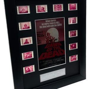 May include: A framed movie poster for the 1978 film "Dawn of the Dead" with a black frame and a silver plaque. The poster features a zombie with a red background and the text "When there's no more room in HELL the dead will walk the EARTH". The poster also includes film strips with scenes from the movie.