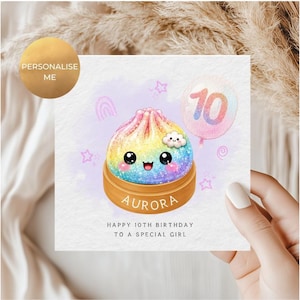May include: A square birthday greeting card featuring a rainbow-coloured, glittery dumpling character in a wooden steamer basket. The card includes a pink balloon with the number 10, the name AURORA, and the text HAPPY 10TH BIRTHDAY TO A SPECIAL GIRL.