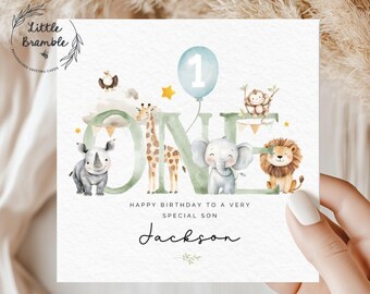 Puede incluir: Tarjeta de felicitación de cumpleaños personalizada con ilustraciones de animales de la selva. La palabra "ONE" se muestra con una jirafa, un elefante, un león y un rinoceronte. Un globo azul con el número "1" flota encima.