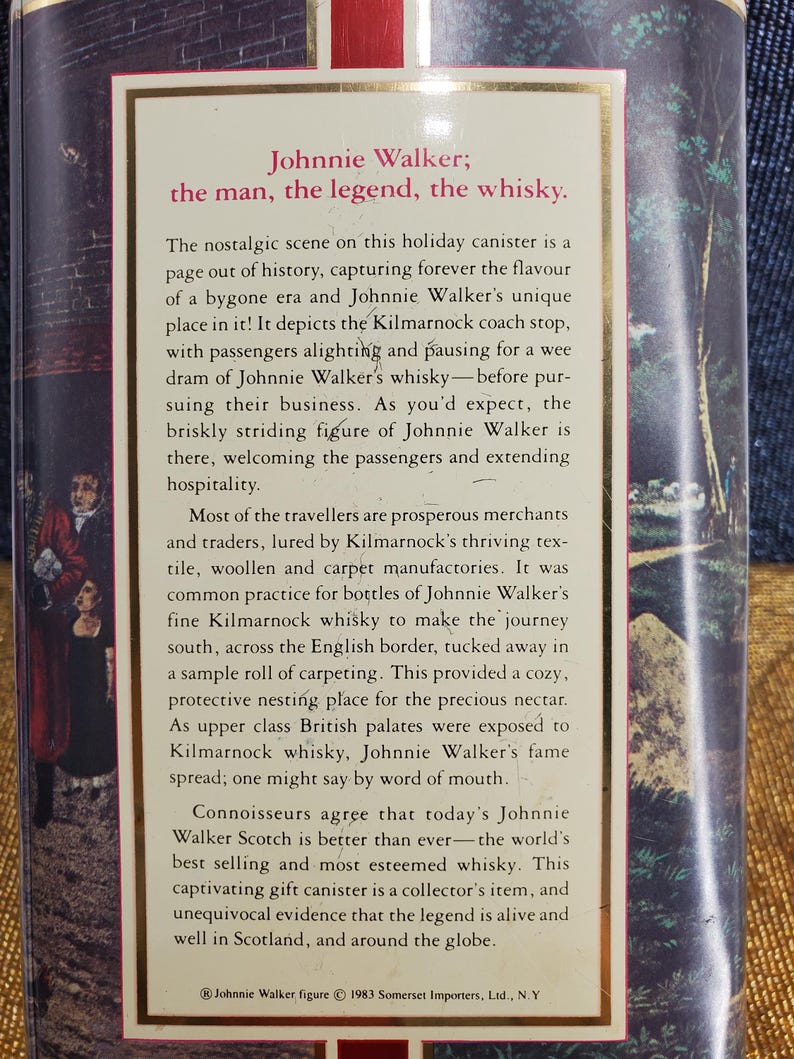 May include: A vintage Johnnie Walker whisky canister with text. The text reads "Johnnie Walker; the man, the legend, the whisky." The canister features a nostalgic scene of a coach stop and passengers.