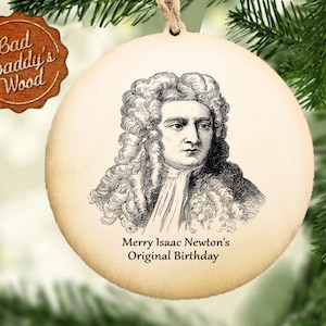 Può includere: Un ornamento rotondo in legno con un'illustrazione in bianco e nero di Isaac Newton. L'ornamento ha il testo "Buon compleanno originale di Isaac Newton" stampato su di esso.