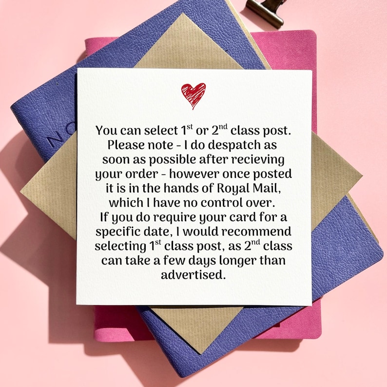 May include: A square white card with a red heart illustration, layered on top of a pink, blue, and tan stationery. The card contains text about postal options and delivery times.