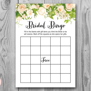 Op de afbeelding: Een printbare bruiloftbingo-kaart met een bloemige rand. De kaart heeft een 5x5 raster met het woord "Free" in het middelste vakje. De tekst "Bridal Bingo" staat bovenaan de kaart.