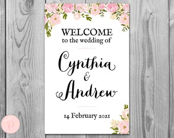 May include: A white wedding sign with pink floral borders. The text reads "Welcome to the wedding of Cynthia & Andrew 14 February 2021".