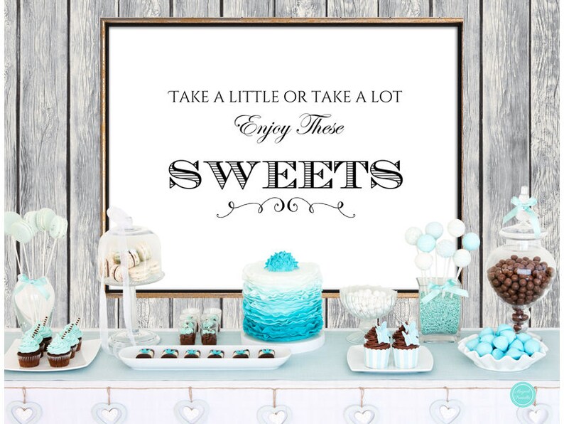 May include: A dessert table with a sign that says "Take a little or take a lot Enjoy these SWEETS". The table is decorated with blue and white decorations and has a variety of sweets, including cupcakes, cake pops, and chocolate candies.