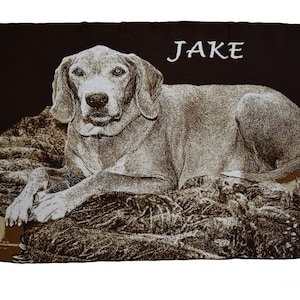 May include: A brown and tan personalized blanket with a dog's face and the name "JAKE" printed in white.