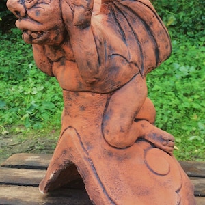 Puntale del tetto angolato con gargoyle dalla lingua impertinente