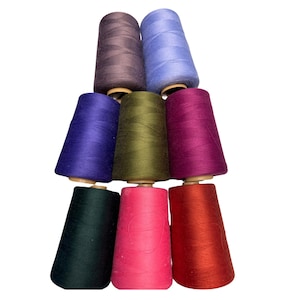 May include: A set of ten spools of thread in various colors, including purple, blue, green, red, and brown. The spools are arranged in a pyramid shape.