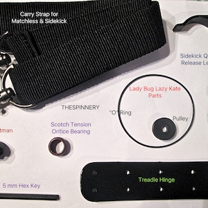 May include: A set of black parts for a sewing machine, including a carry strap, a quick release lever, a footman knob, a tension orifice bearing, a pulley, an O-ring, a treadle hinge, and a 5 mm hex key. The parts are labeled with their names.