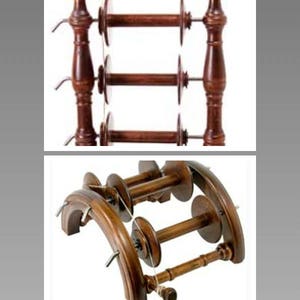 May include: Two wooden yarn winders, one with three spools and the other with two spools. Both winders are made of dark brown wood and have a traditional design.