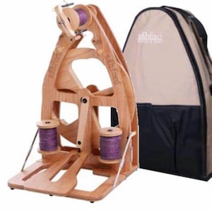 May include: A wooden spinning wheel with a large wheel and two smaller bobbins. The spinning wheel is on a stand and comes with a beige carrying case with the Ashford logo.